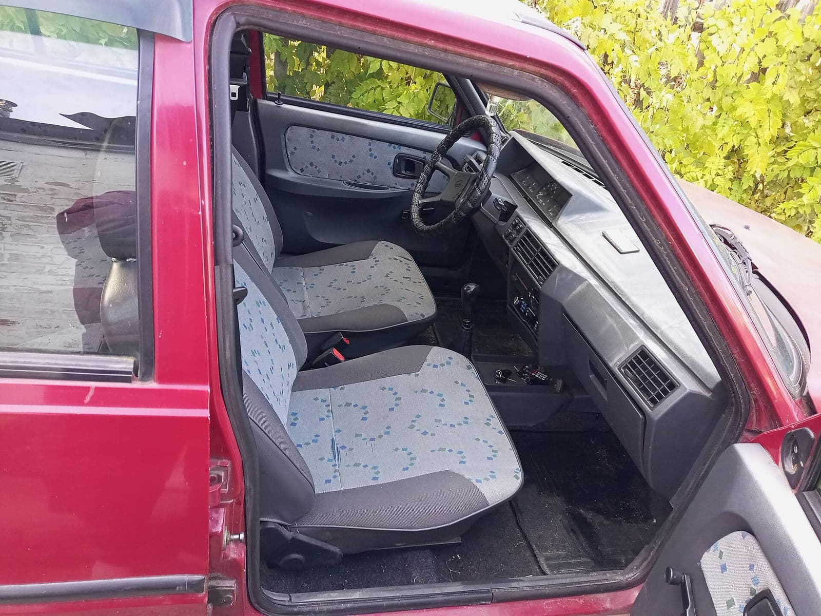 Cloth front seats and dashboard seen through an open car door