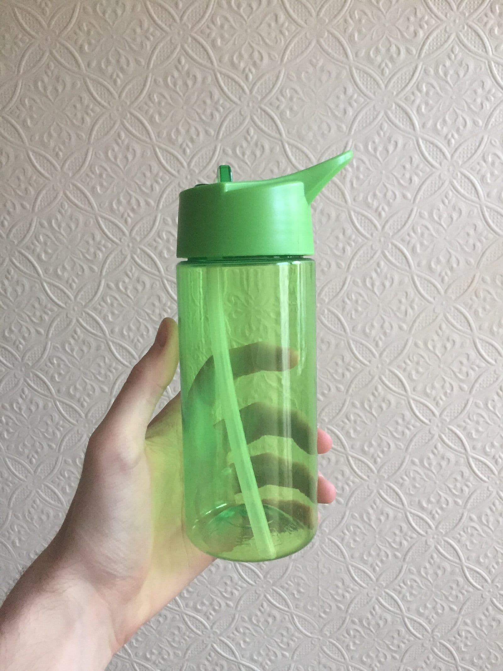 A reusable plastic water bottle with a flip-up straw lid