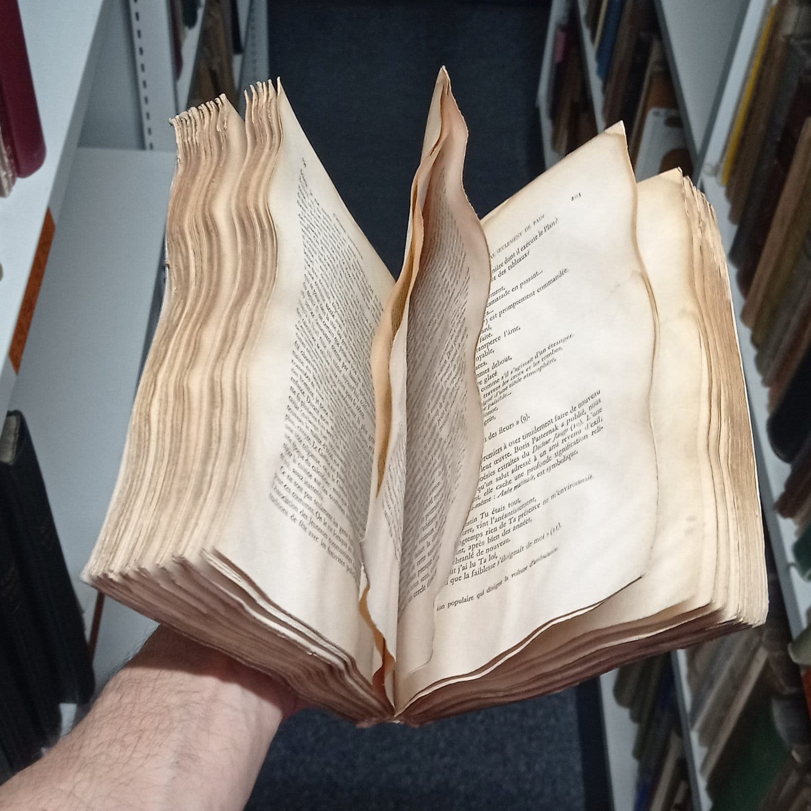 An old water-damaged book with warped, stained pages
