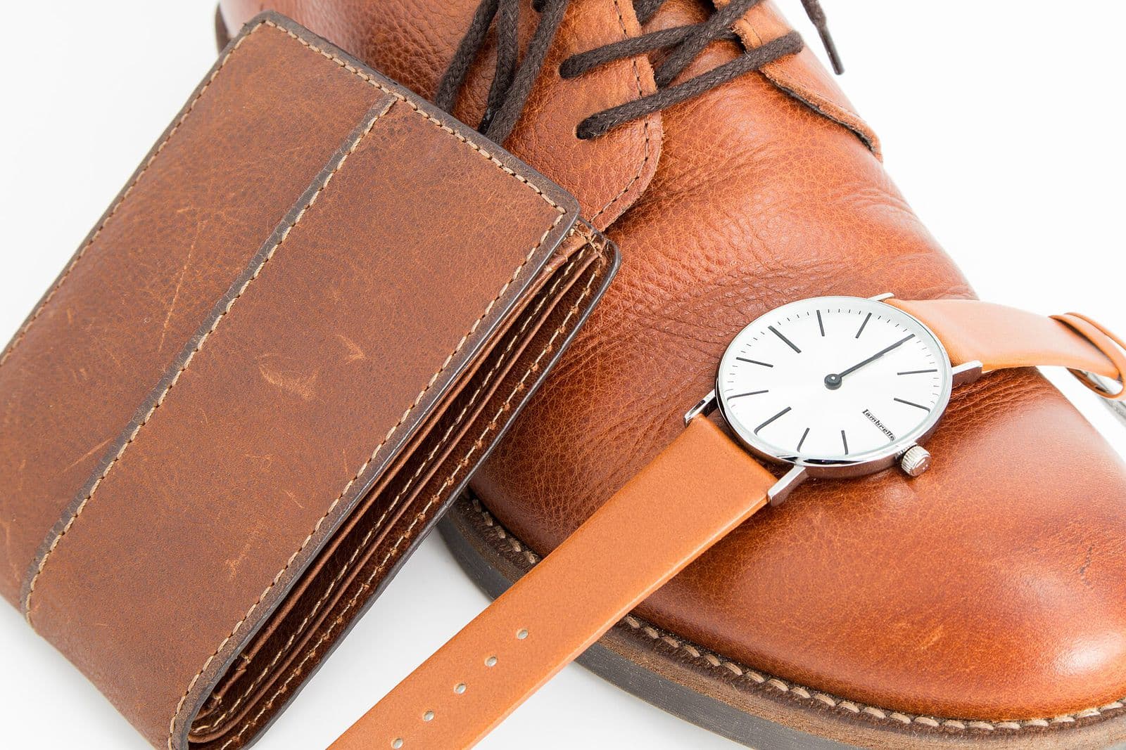 A brown leather wallet, leather shoe and leather watch strap